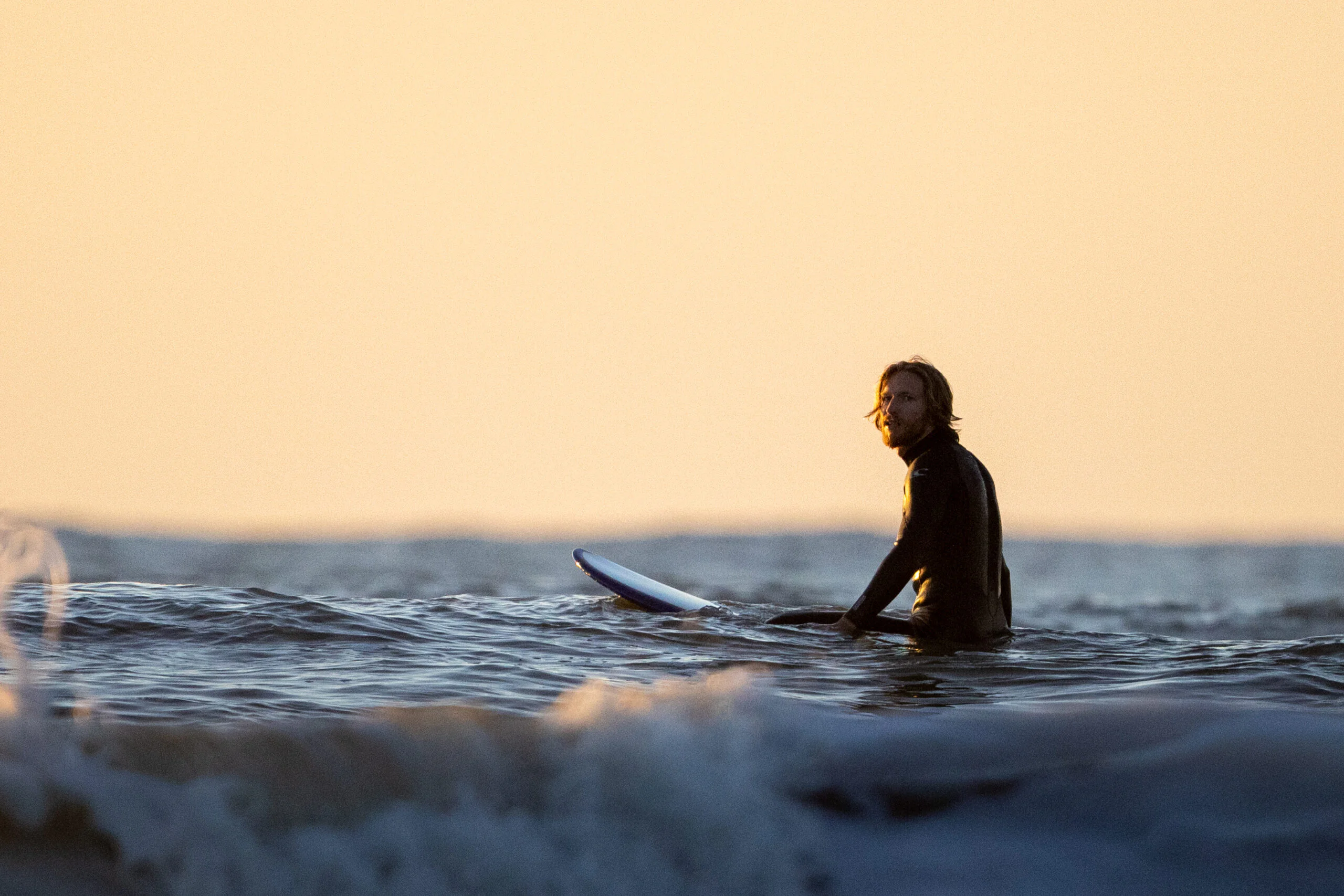 Zittende surfer in het water in ouddorp